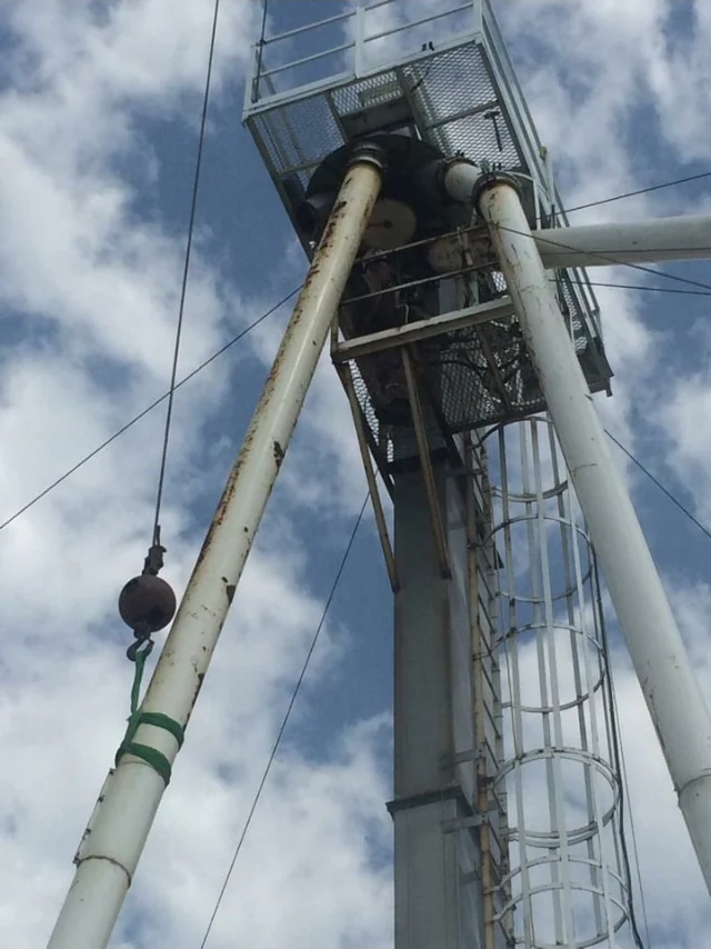 White spouting supported by a lifting sling below an elevated access platform