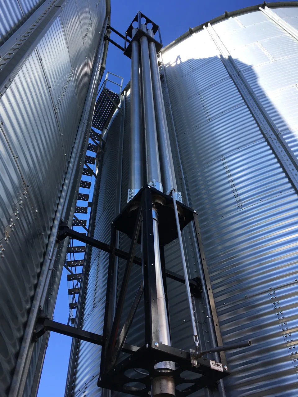 Bucket elevator trunking between grain bins