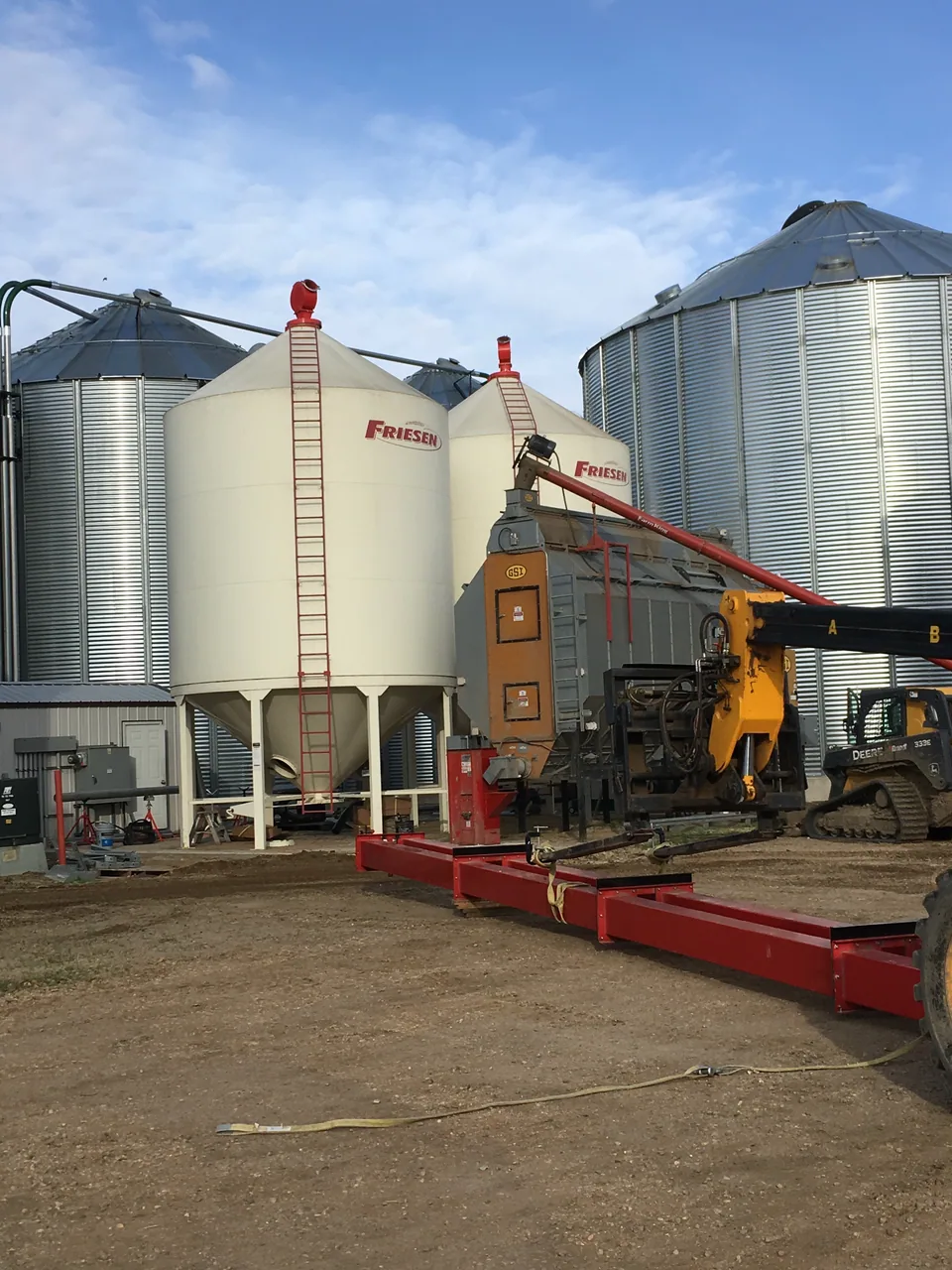 Positioning the red bucket elevator beside the dryer