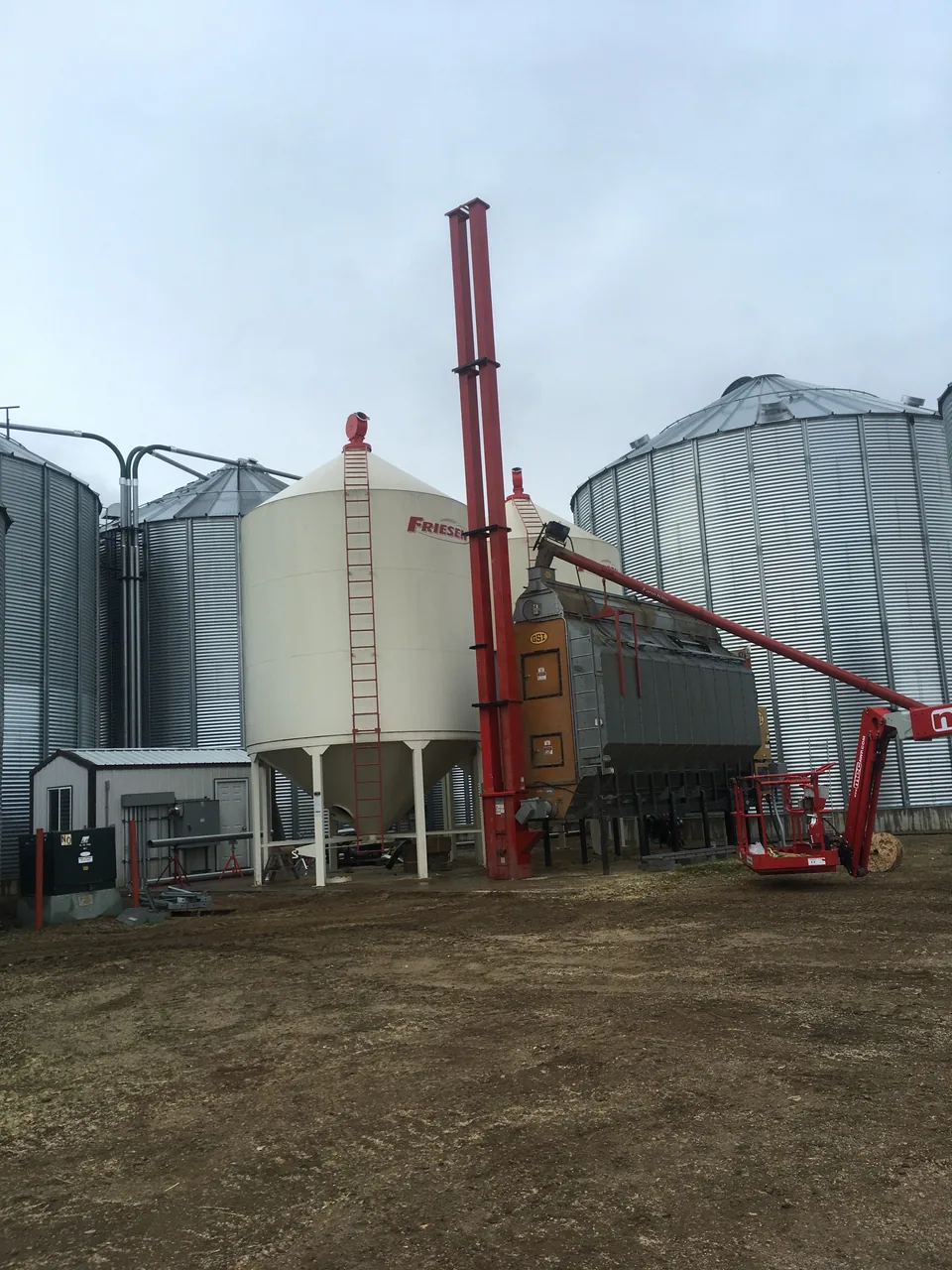 Positioning the red bucket elevator beside the dryer
